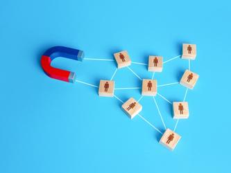 Magnet attracting wooden blocks with representations of people on them
